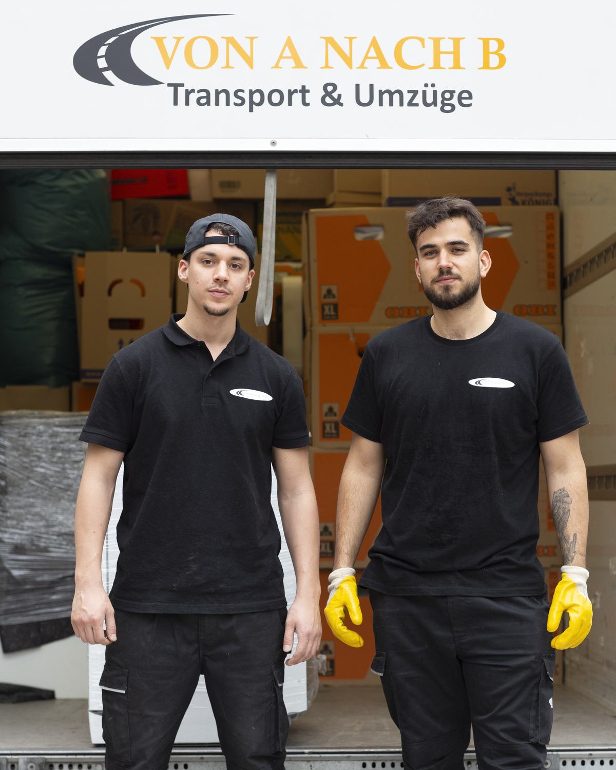 Lino Rischert und Yousf Ezznati vor dem geöffneten Umzugswagen von Von A nach B